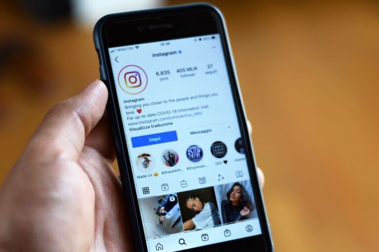 Nákup polských sledujících na Instagramu – telefon s profilem a polskou vlajkou
