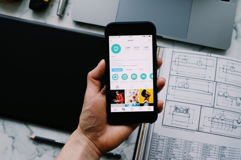 Telefon se zobrazeným Instagram profilem a stylizovaným fontem v bio