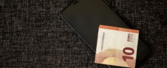 Telefon s aplikací TikTok a eurové mince symbolizující cenu sledujících a lajků
